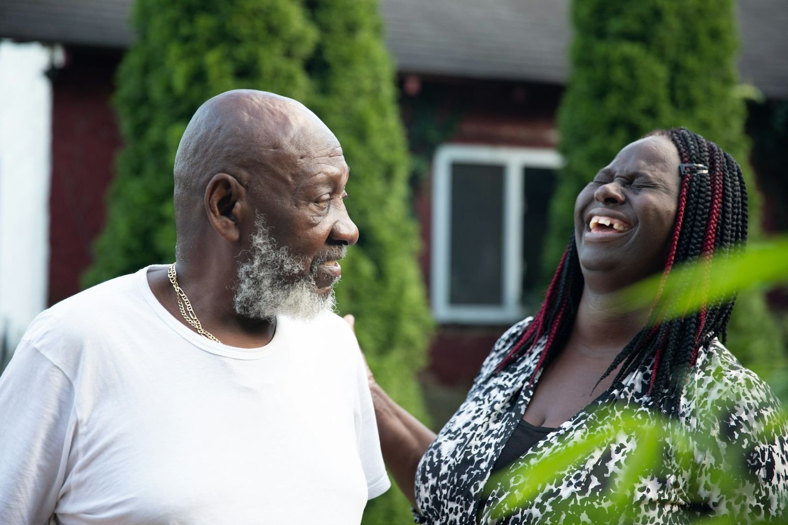 Two neighbours sharing a laugh outside their home