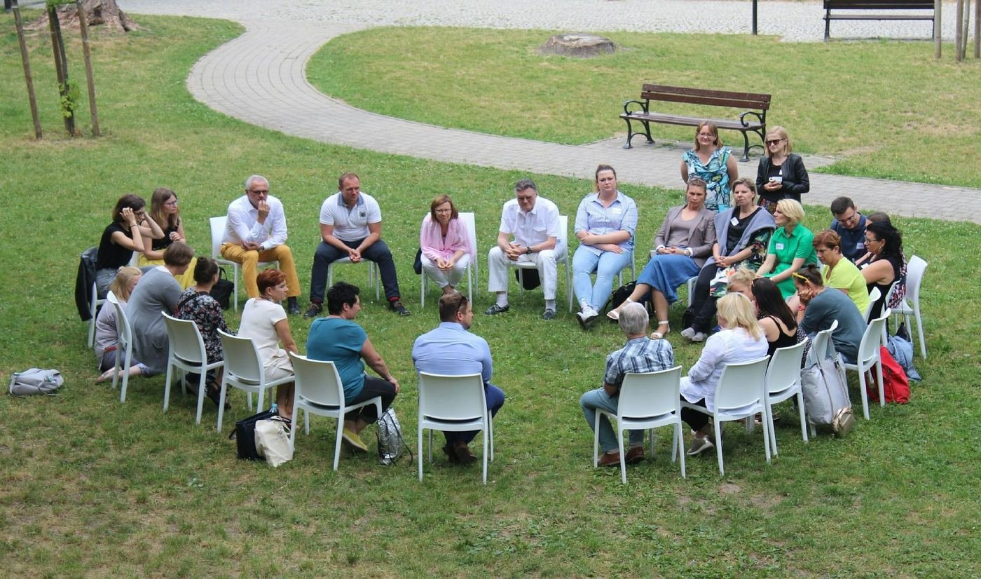 Community members meeting in a circle outdoors